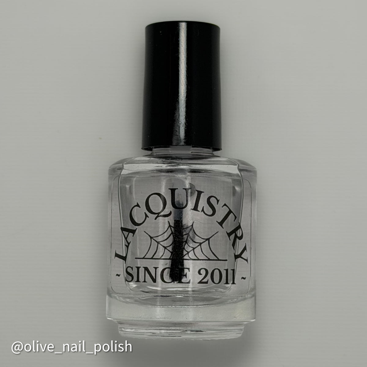 bottle of clear lacquer topcoat with Lacquistry Since 2011 on front of bottle. liquid is clear