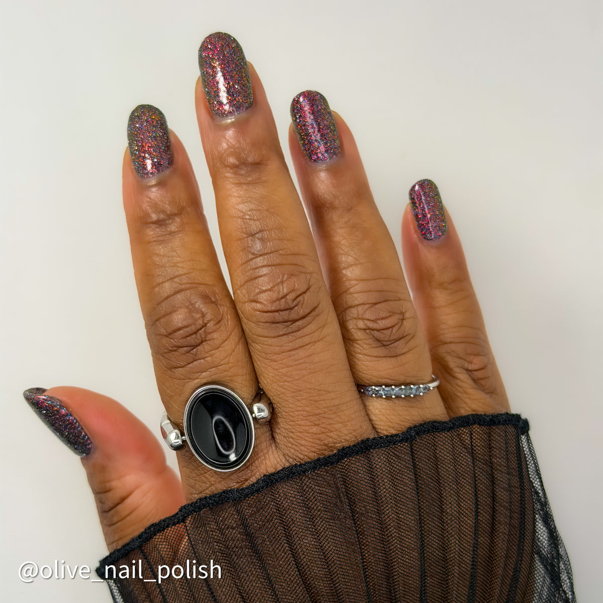 red sparkles with lavender reflective glitter in a dark base over nails