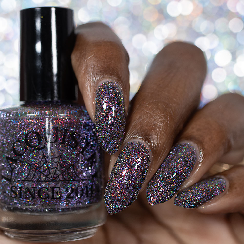 red sparkles with lavender reflective glitter in a dark base over nails holding bottle that says LACQUISTRY SINCE 2011