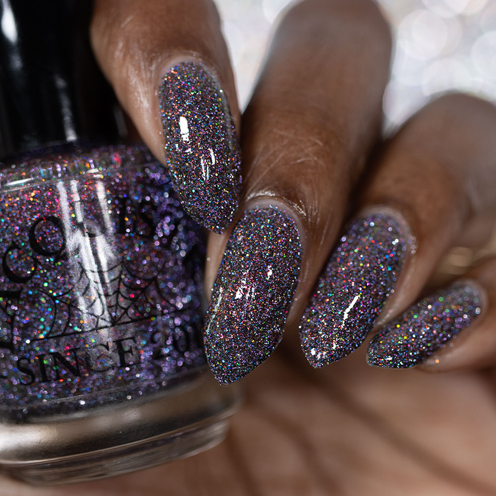 red sparkles with lavender reflective glitter in a dark base over nails holding bottle that says LACQUISTRY SINCE 2011