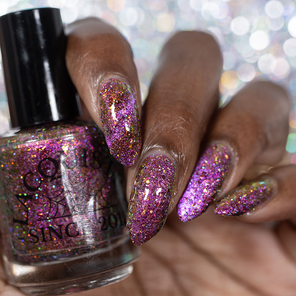 flakie magnetic polish showing red, orange, gold, green flakes, holo glitter, and magnetic effect of fuchsia to purple