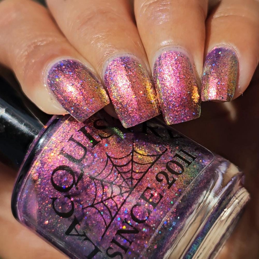 medium skin toned hand with medium/long square nails wearing metallic purple pink sparkle nail polish holding matching bottle of light purple Lacquistry nail polish
