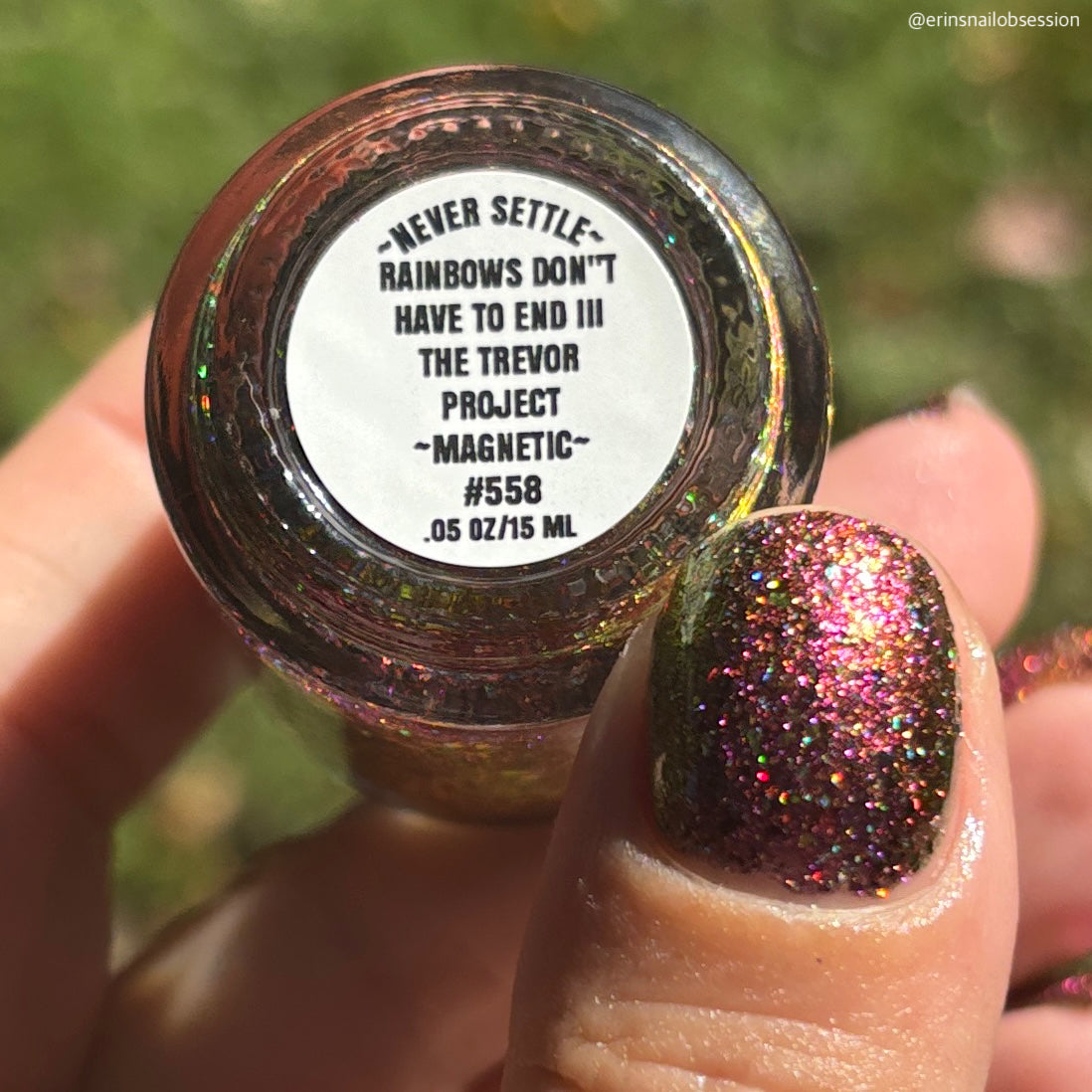 flakie magnetic polish showing red, orange, gold, green flakes, holo glitter, and magnetic effect of fuchsia to purple showing the bottom label that says rainbows don't have to end III the Trevor Project