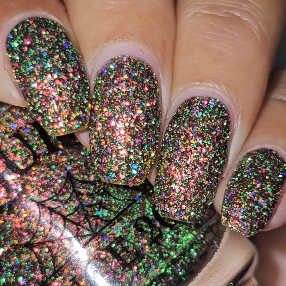 nails painted with sparkly glittery polish showing pink, red, green, gold and orange glitters in a darkened base color with green reflective glitter