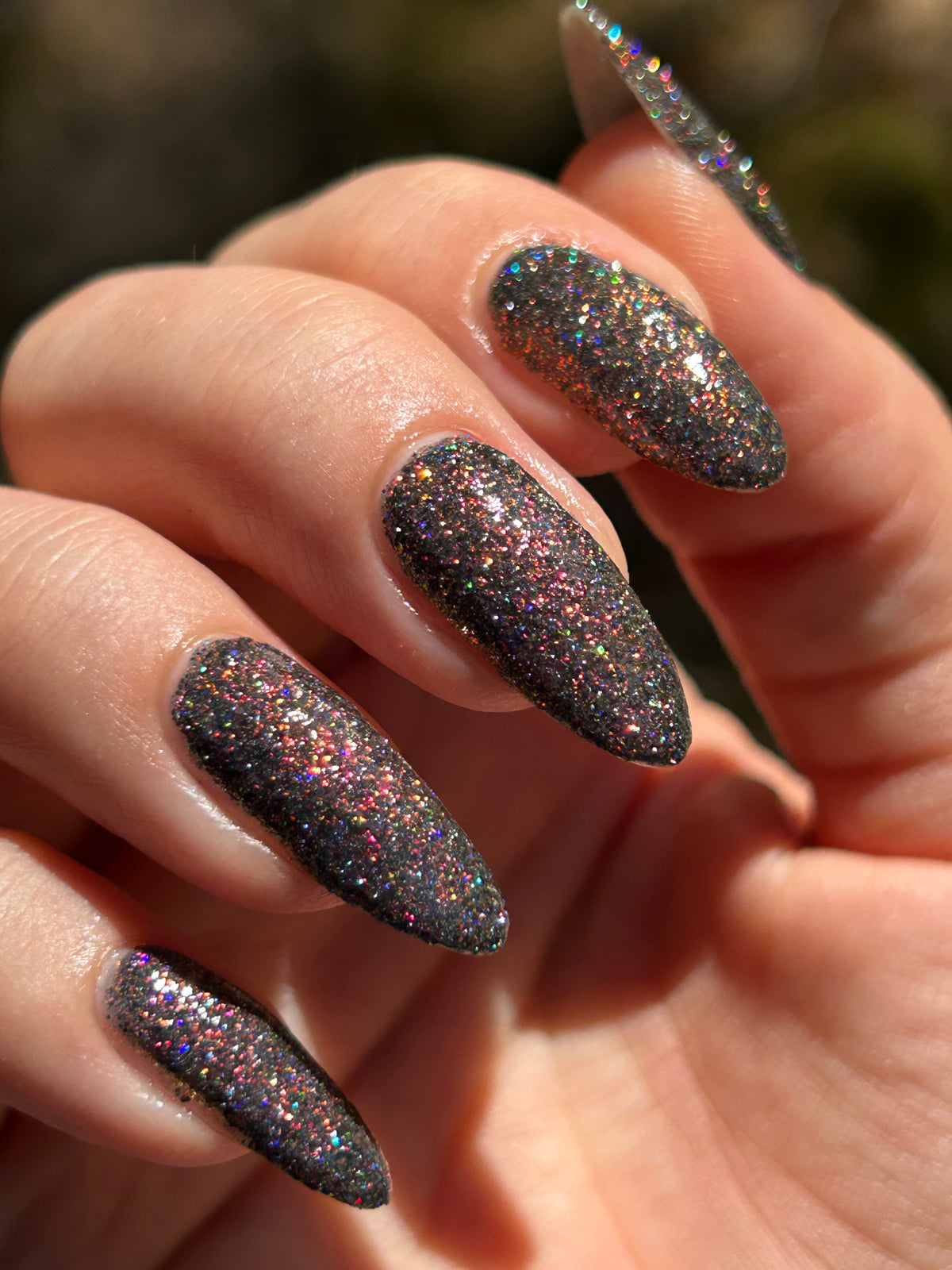 red sparkles with lavender reflective glitter in a dark base over nails 