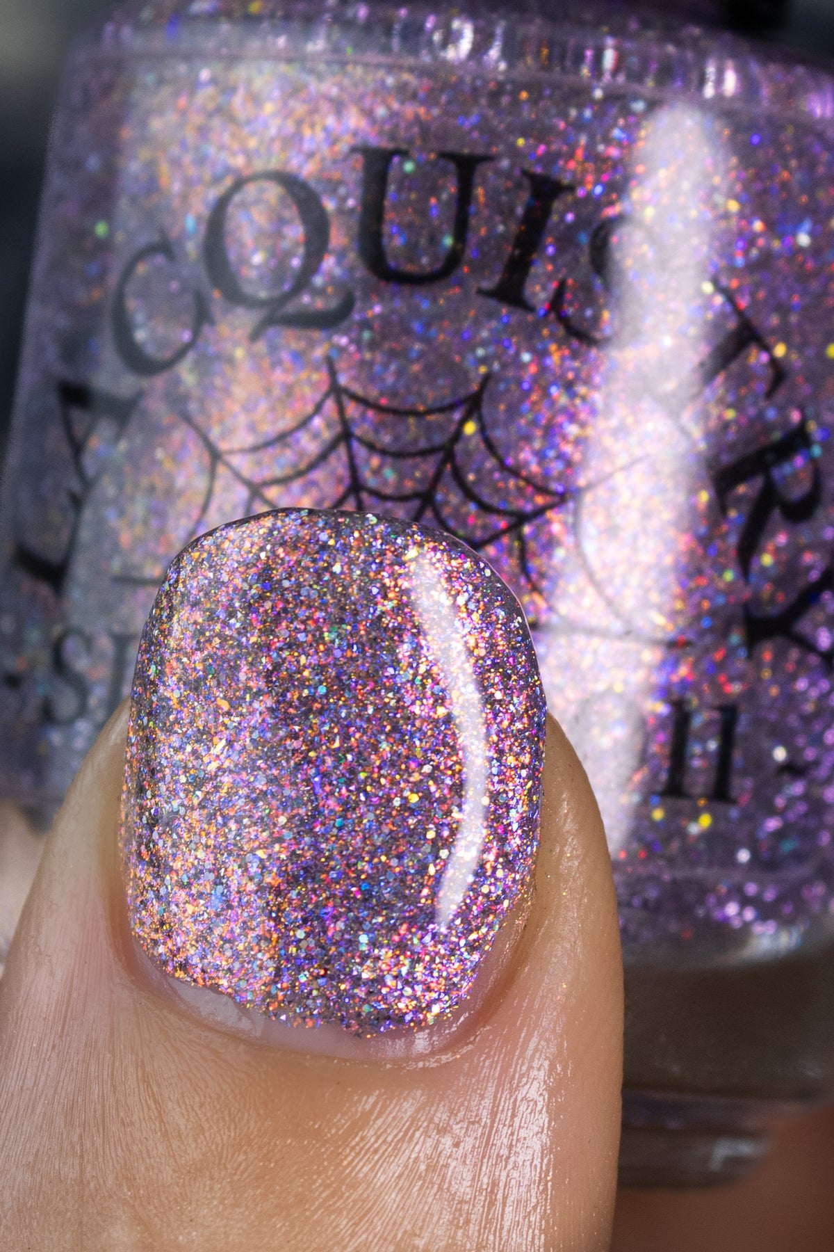 lavender sparkle and holo glitter pink nail polish bottle says LACQUISTRY 