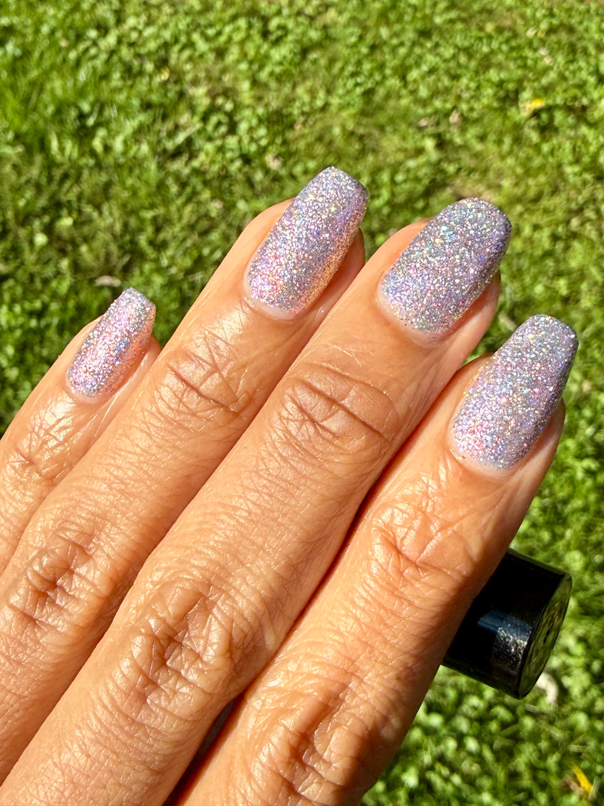 lavender sparkle and holo glitter pink nail polish grass background
