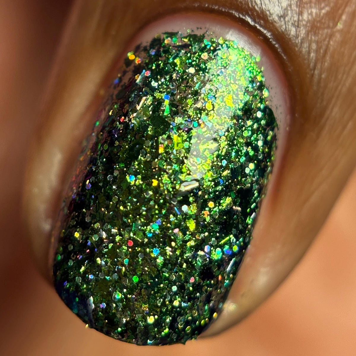 closeup of sparkling green glitter holo and flake nail polish