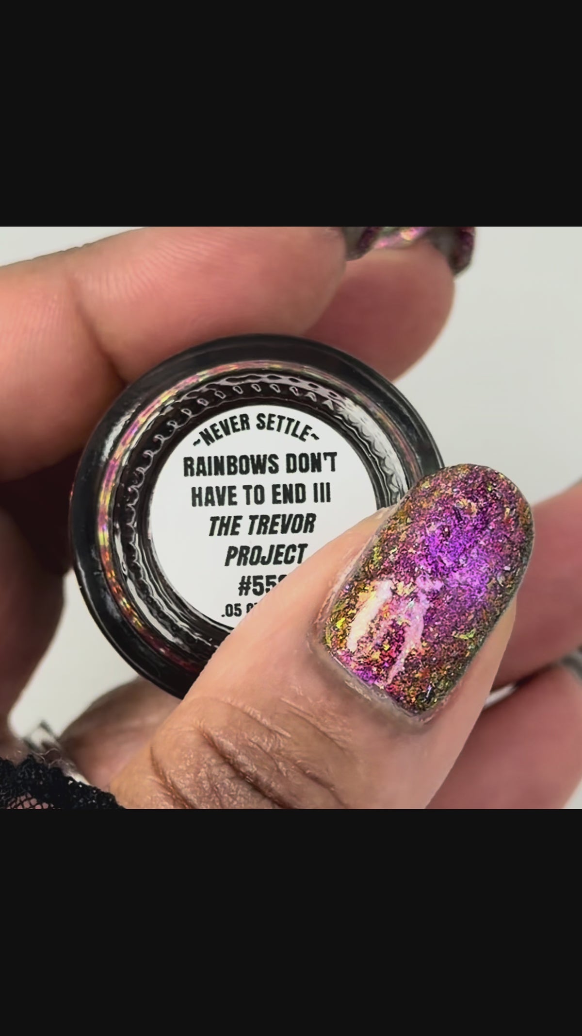 video of flakie magnetic polish showing red, orange, gold, green flakes, holo glitter, and magnetic effect of fuchsia to purple