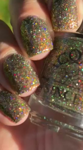 video of nails painted with sparkly glittery polish showing pink, red, green, gold and orange glitters in a darkened base color with green reflective glitter going from sun to shade